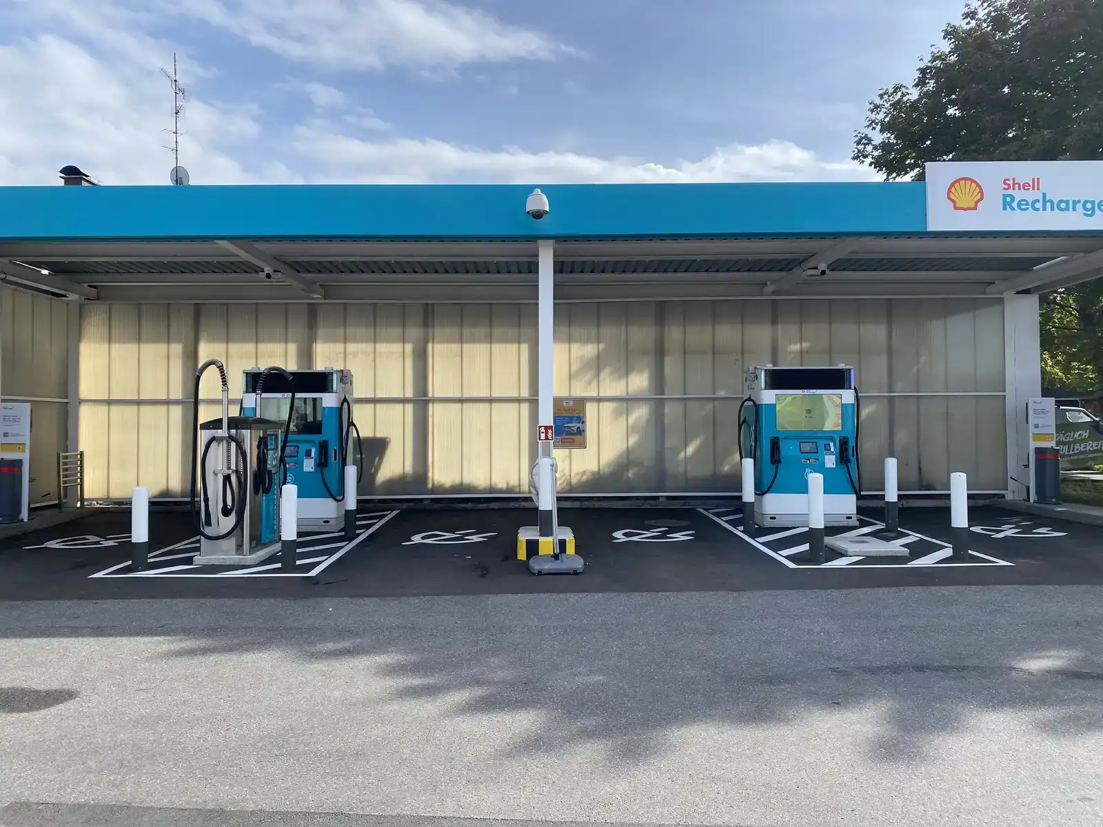 Shell Recharge snellaadstation met witte en turquoise laadpunten onder een overkapping