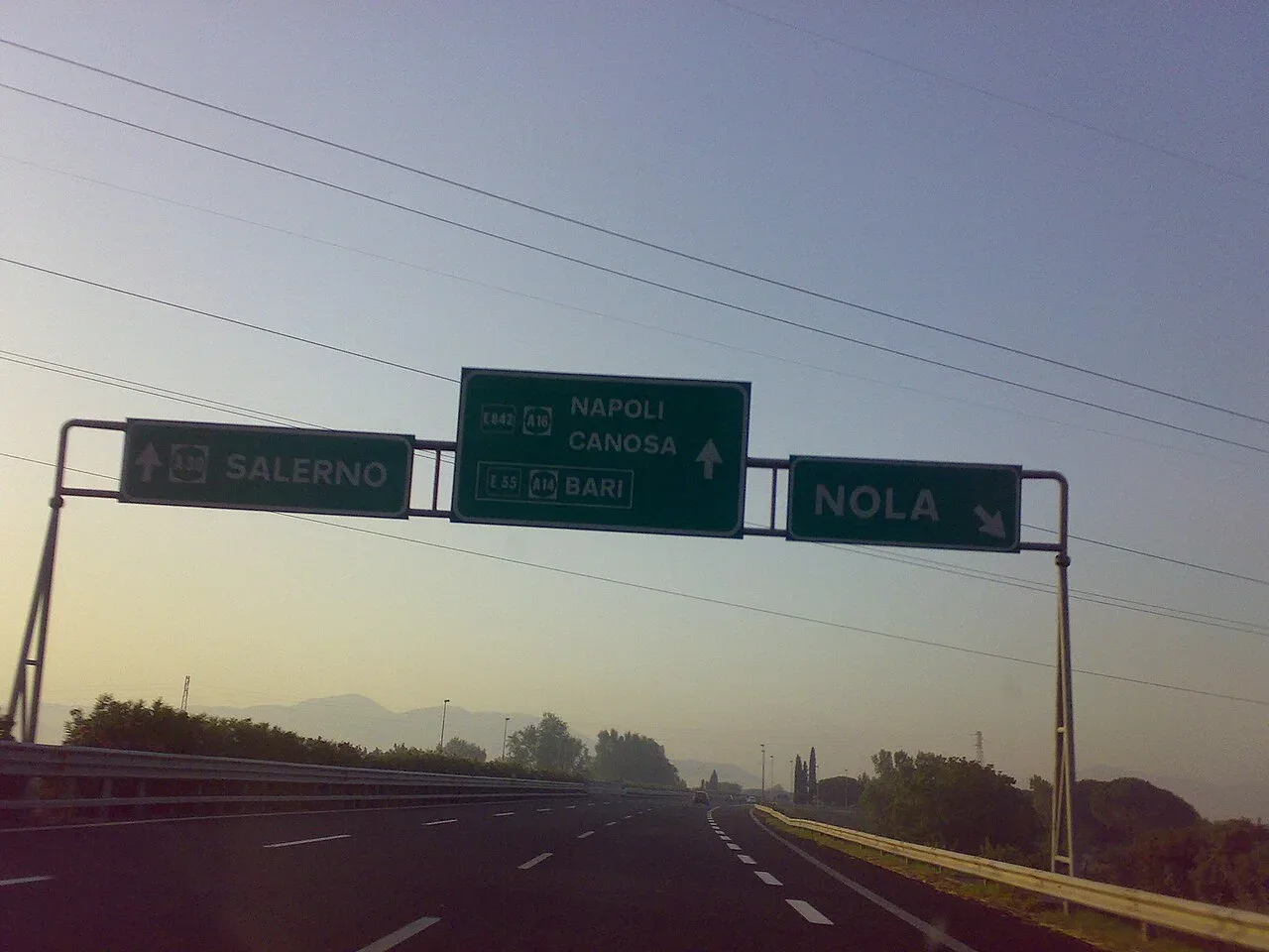 Groene bewegwijzering boven de Italiaanse snelweg A30 met de borden Salerno, Napoli en Nola