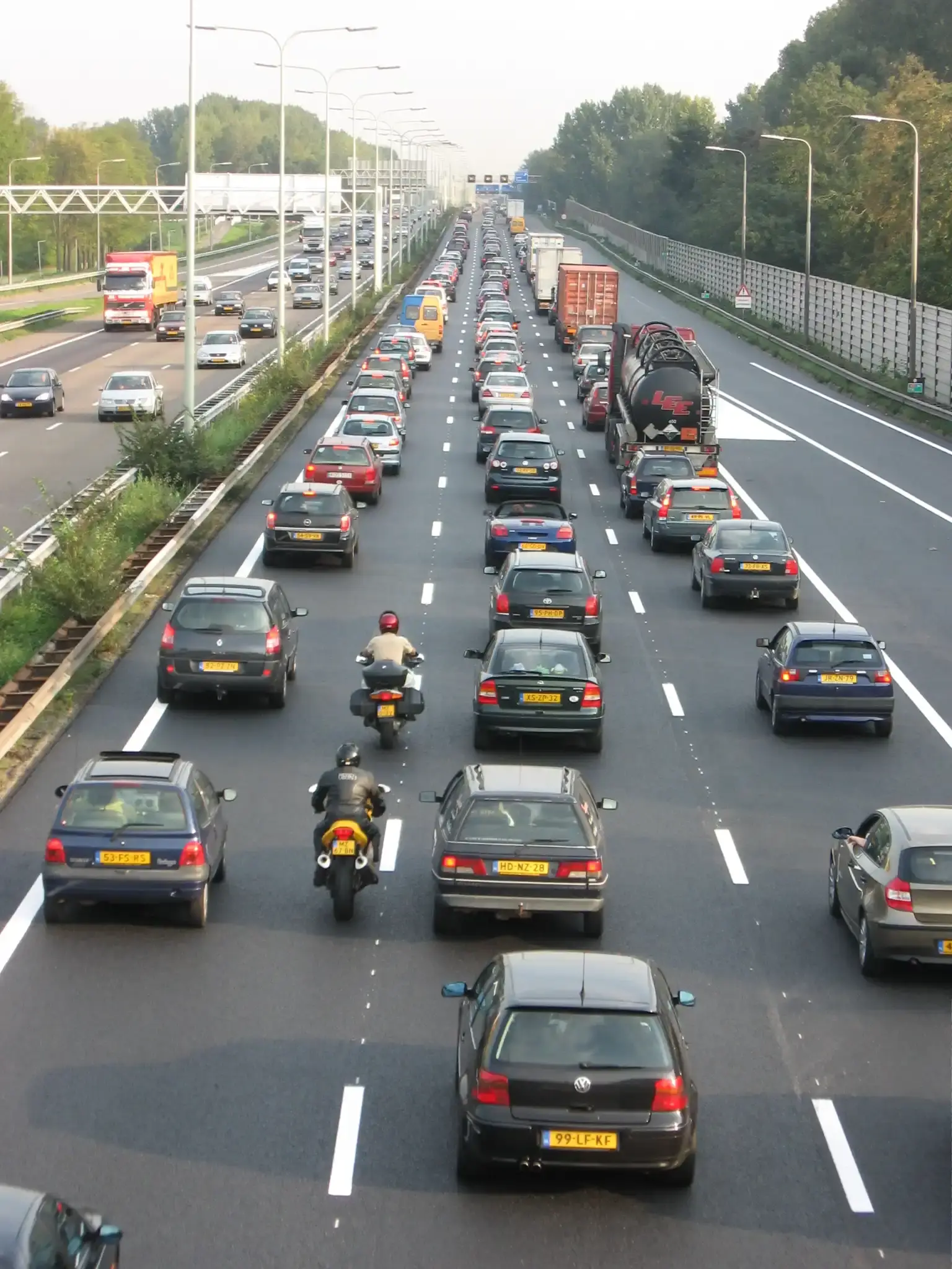 File op de Nederlandse snelweg A13 met rijen auto's, motoren en vrachtwagens