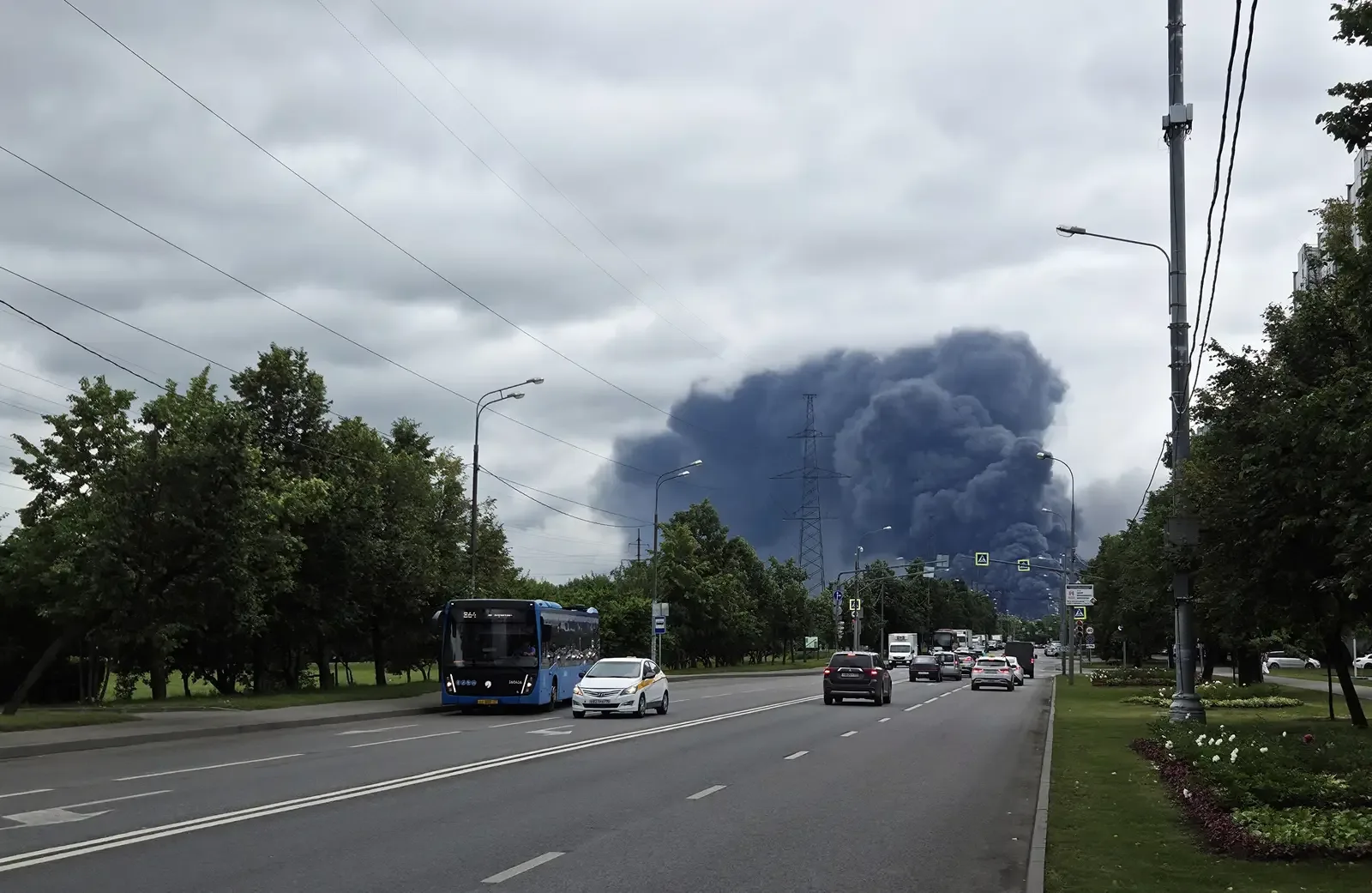 Zwarte rookwolk boven de olieraffinaderij in Moskou na een aanval op 18 juni 2026, gezien vanaf een drukke weg