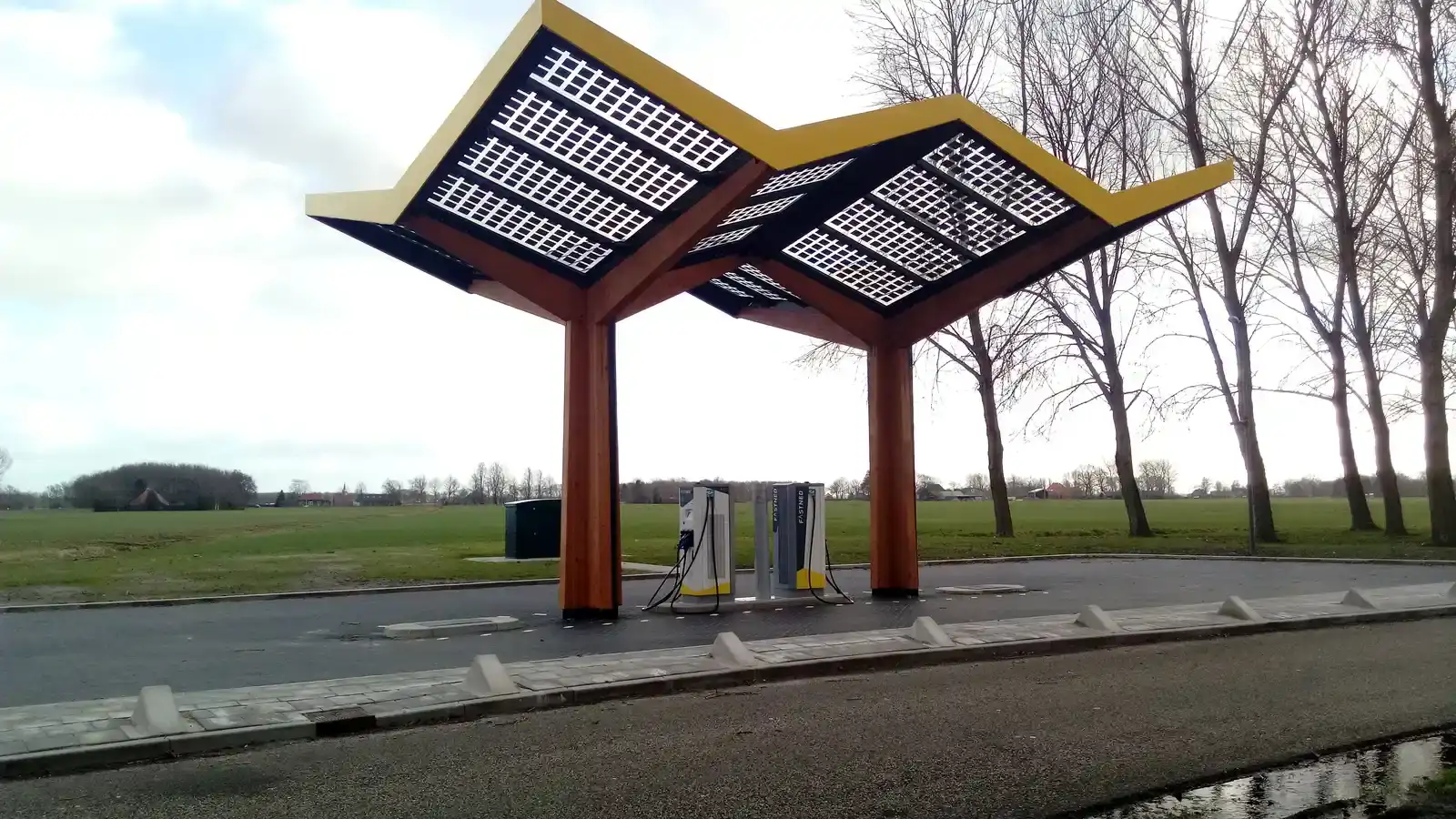 Snellaadstation met geel dak van zonnepanelen langs de weg bij De Wâlden in Friesland