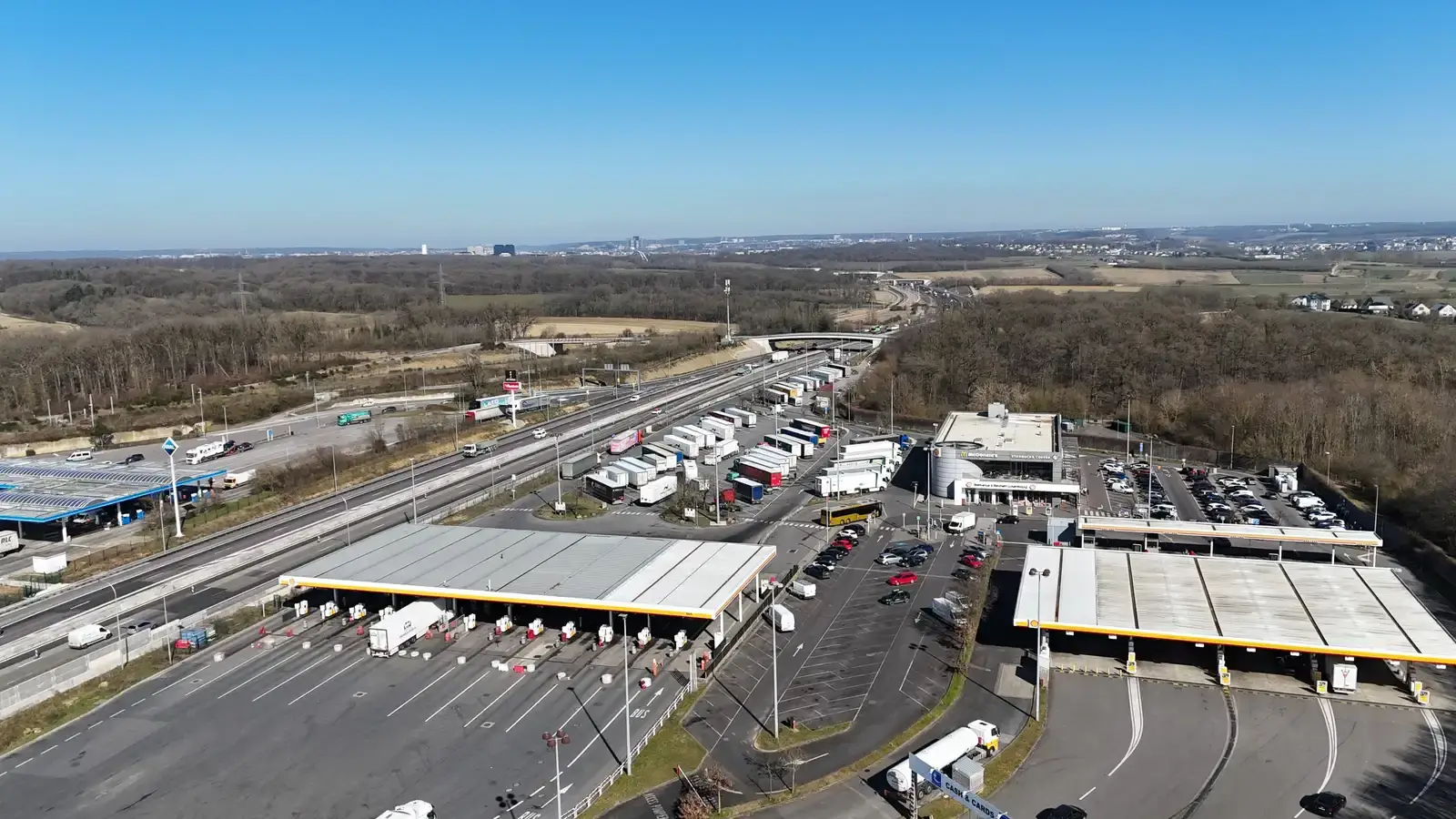 Luchtfoto van de tankstations op de Aire de Berchem langs de A3 in Luxemburg, met rijen vrachtwagens bij de pompen