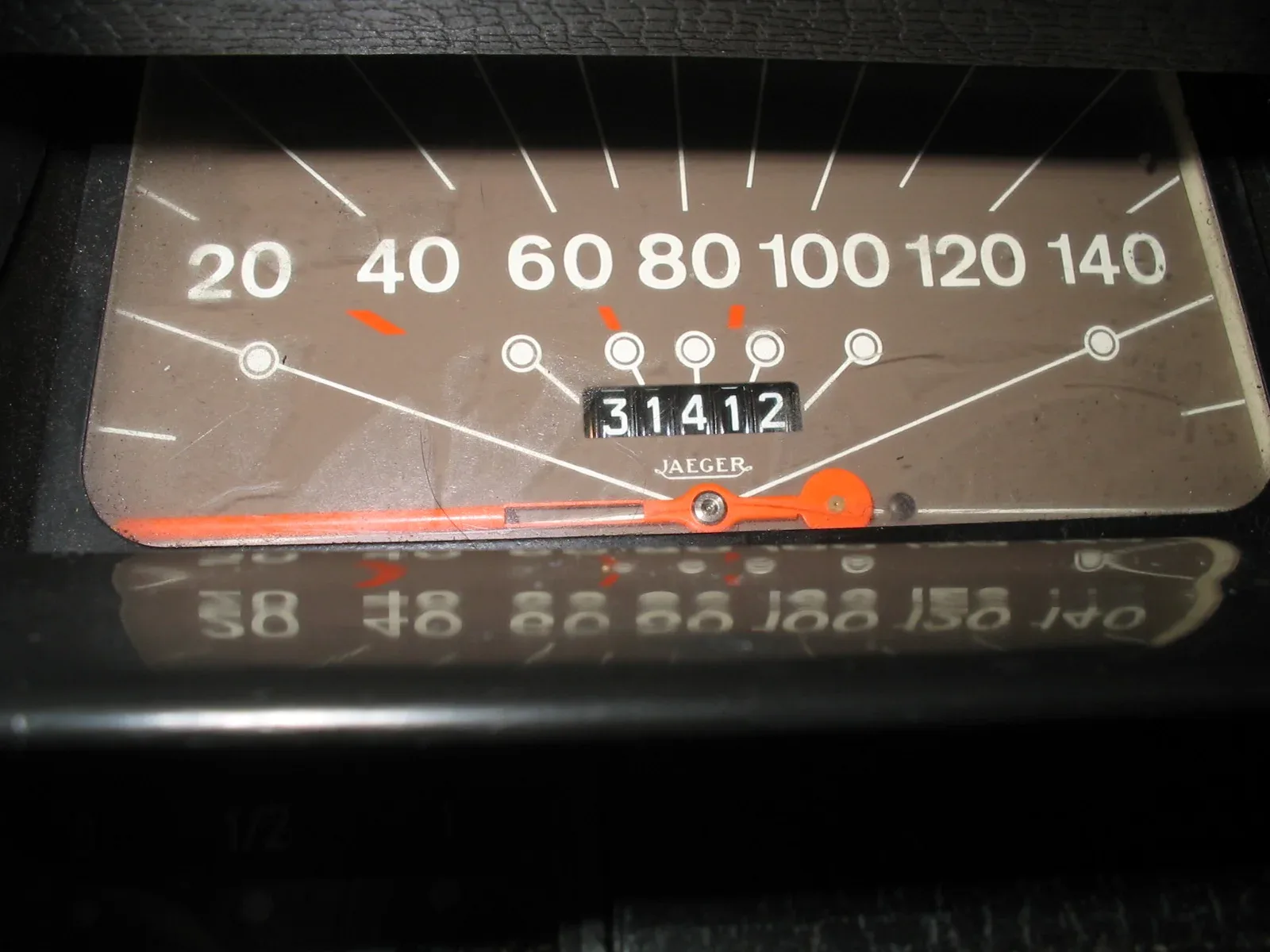 Close-up van een oude snelheidsmeter met rolletjes-kilometerteller die 31412 kilometer aangeeft