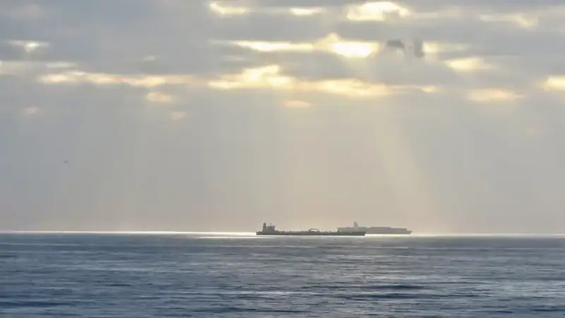 Een olietanker ligt op zee voor anker onder een bewolkte lucht