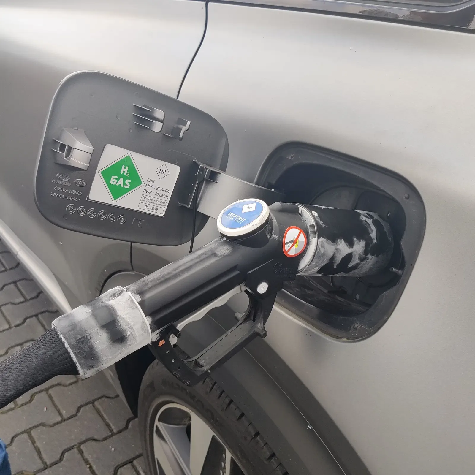 Close-up van een waterstofvulslang en -pistool bij een tankstation