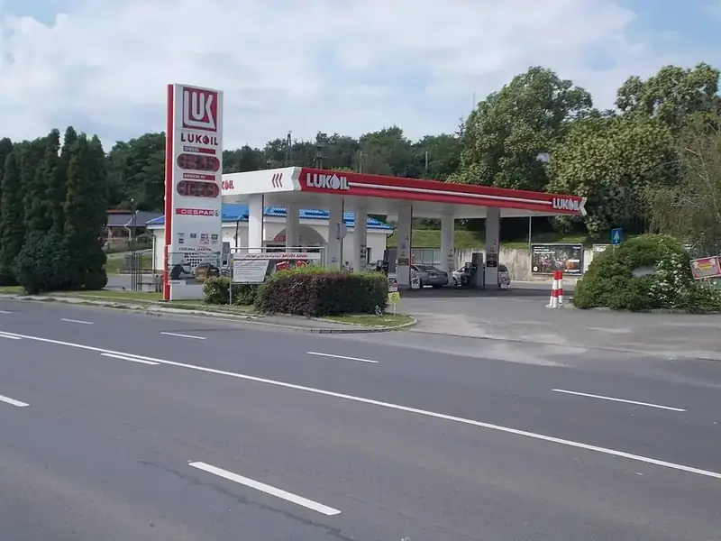 Tankstation van Lukoil langs een weg in Hongarije met bomen op de achtergrond