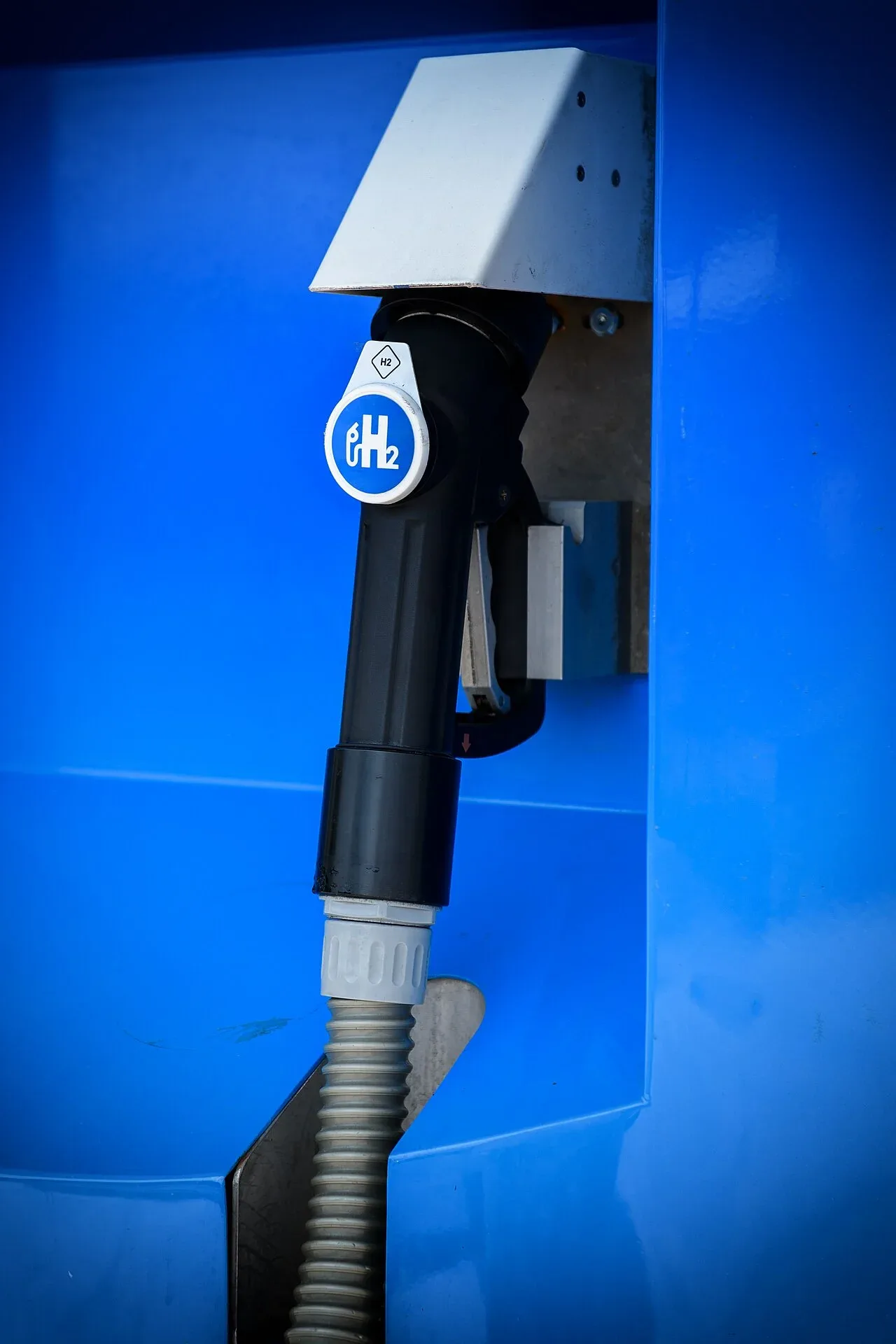 Waterstofvulpistool met H2-logo aan een blauwe tankzuil