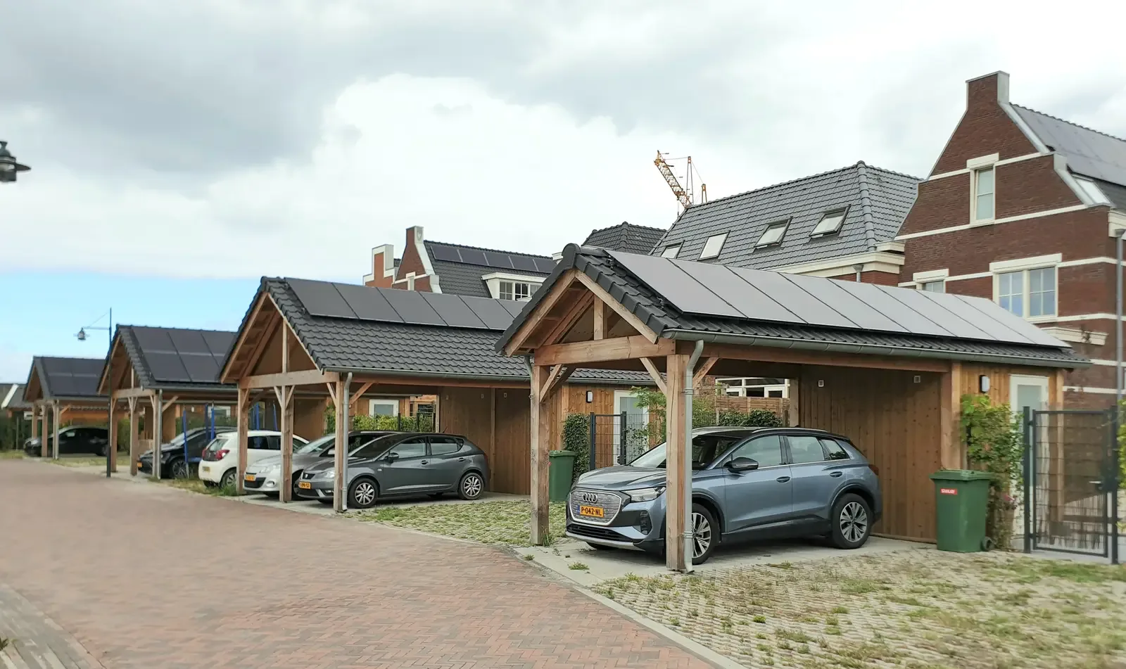 Elektrische auto onder een houten carport met zonnepanelen in een woonwijk in Maassluis