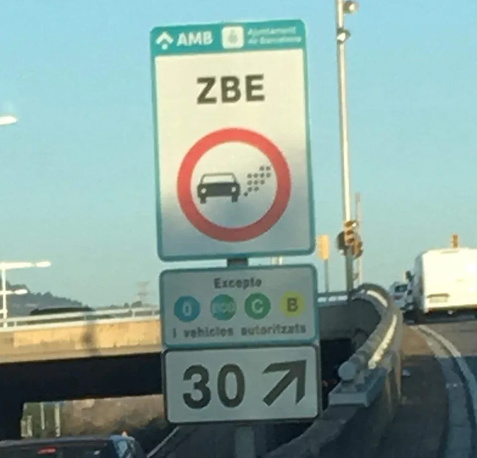 Verkeersbord ZBE met rood verbodsteken en onderbord met toegestane milieustickers 0, ECO, C en B bij afrit 30 van de Ronda Litoral in Barcelona